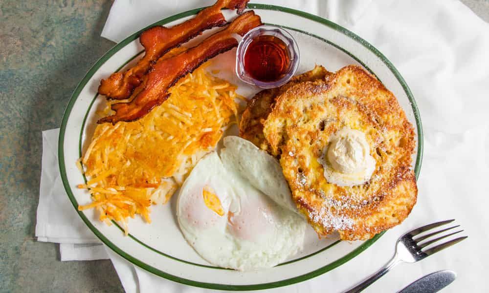 Stack of fluffy buttermilk pancakes topped with whipped cream