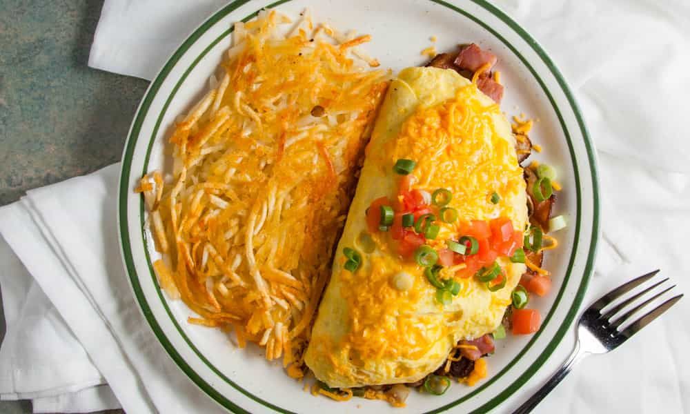 Fluffy three-egg omelet filled with fresh vegetables and melted cheese